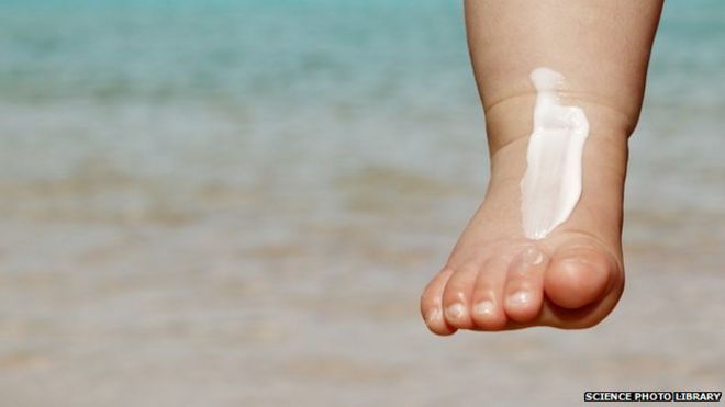 Солнцезащитный крем на ноге младенца