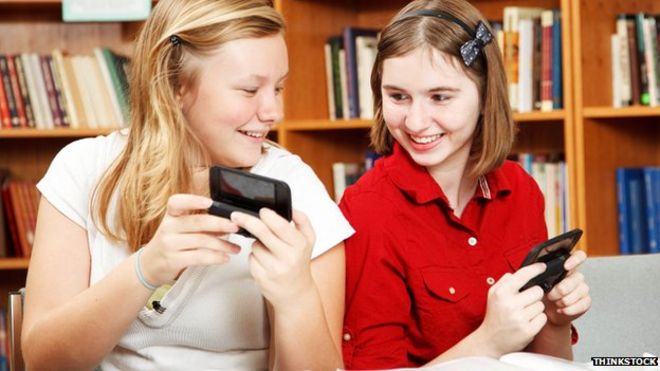 школьницы с мобильными телефонами