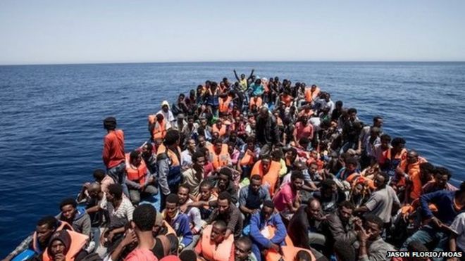 Мигранты толпятся на палубе своей деревянной лодки у побережья Ливии, 14 мая 2015 года
