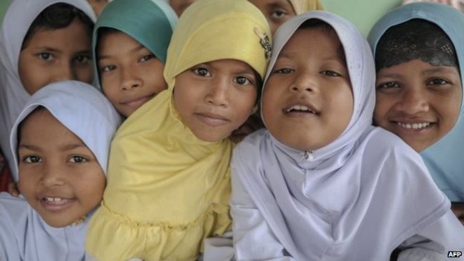Дети из числа этнических рохинджа из Мьянмы, проживающие в Малайзии, позируют для фотографий после того, как они пообедали в их общественной школе в Ампанге в пригороде Куала-Лумпура 20 мая 2015 года.