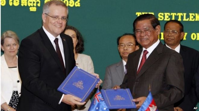 Министр иммиграции Австралии Скотт Моррисон (слева) показывает подписанный документ с министром внутренних дел Камбоджи Сар Кенгом в Пномпене (сентябрь 2014 г.)