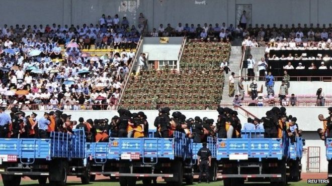 Грузовики, перевозящие преступников и подозреваемых, замечены во время массового митинга приговоров на стадионе в Йили, Синьцзян-Уйгурский автономный район, 27 мая 2014 года