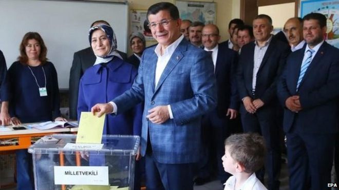 На раздаточном материале, предоставленном пресс-службой премьер-министра Турции, 7 июня 2015 года на избирательном участке в Конье, Турция, голосует премьер-министр Ахмет Давутоглу (С)