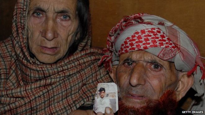 Кашмирские родители осужденного убийцы Шафката Хуссейна демонстрируют фотографию своего сына в Музаффарабаде,