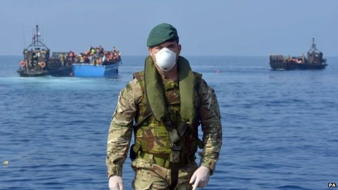 Королевские морские пехотинцы и военнослужащие из HMS Bulwark помогают спасать мигрантов, застрявших на лодке в тридцати милях от ливийского побережья