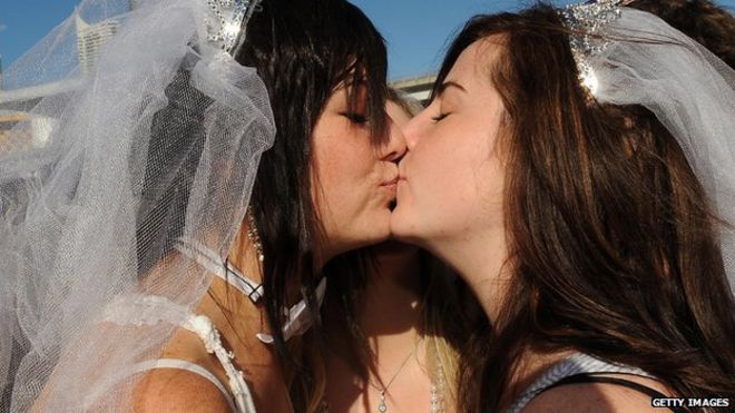 Лесбиянки Лорен Коули (слева) и Мишель Рикеттс запечатлели свои обеты поцелуем возле конференции правящей лейбористской партии во время массовой «нелегальной свадьбы» в Сиднее 1 августа 2009 года.