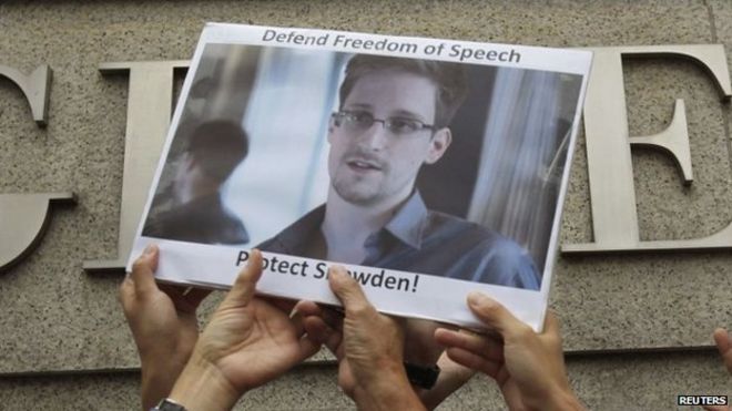 Протестующие в поддержку Сноудена держат его фотографию во время демонстрации возле консульства США в Гонконге