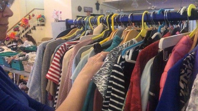 Shopper looking through a rail of women's clothing