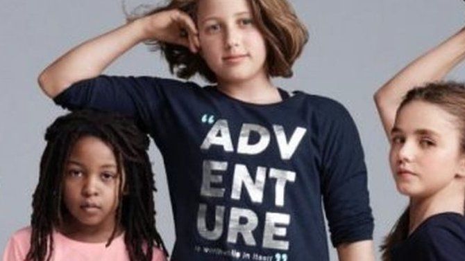 An advert showing a white girl resting her arm on a black girl's head