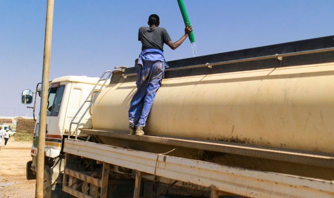 A man fills water for transport into a tanker on April 03, 2017 in Kebri Dahar, Ethiopia.