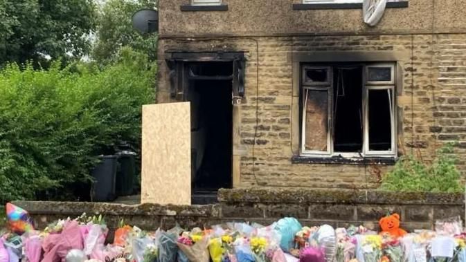 Floral tributes outside where the family died