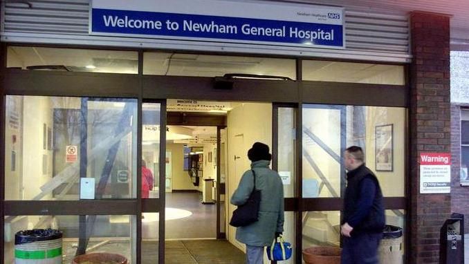Two people walk in to Newham Hospital entrance