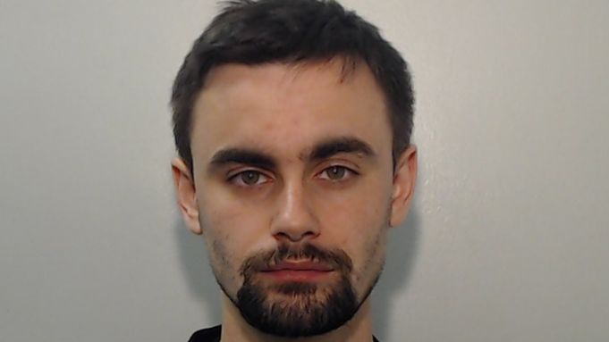 Police picture of Hugh Nelson - he has dark cropped hair and a dark goatee