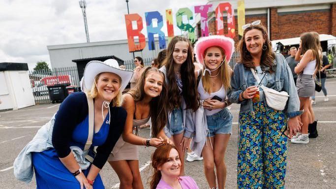 Six women stand together for image outside of Ashton Gate music event