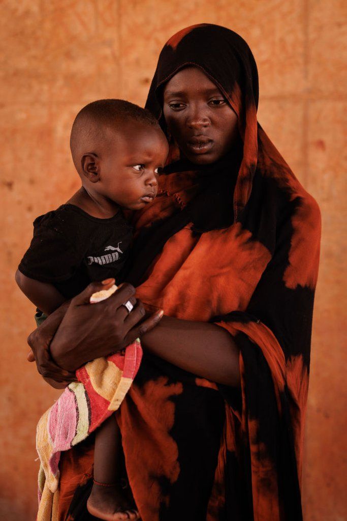 Kobra Yagoub-Sharaf with her daughter Eldin from Darfur pose for a portrait on the Chad Sudan border after having their documents processed on April 20, 2024 in Adre, Chad.