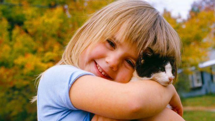A child holding a kitten