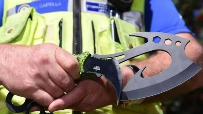 A police officer holds a seized zombie knife