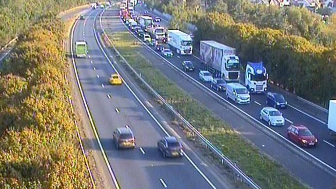 A CCTV image of road delays on the A14, showing cars and lorries stacked up on one side.