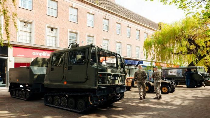 Two military personnel stand with a tank in Hull city centre