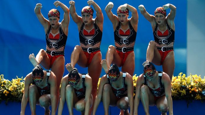 Brazilian women sport black and red ornamental bikinis as they prepare to dive at the synchronised swimming competition at the 2016 Rio Olympics.