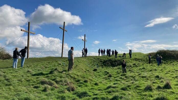 Volunteers put up wooden crosses on hill