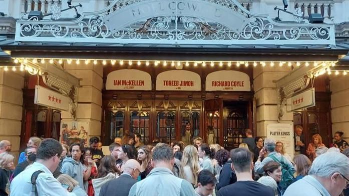 Audience gathered outside the theatre after being evacuated