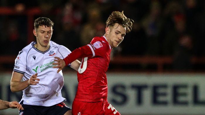  Accrington Stanley's Alex Henderson shields the ball from Bolton Wanderers' Eoin Toal during the Bristol Street Motors Trophy Third Round match between Accrington Stanley and Bolton Wanderers at Wham Stadium on January 10, 2024 in Accrington, England
