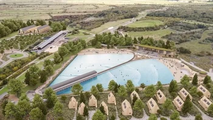 Image shows a planned surf lagoon surrounded by the country park and holiday pods