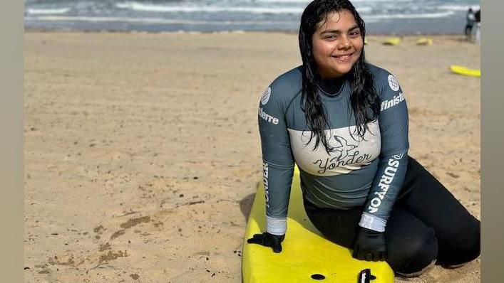 Daniela,17, from El Salvador with a surfing board