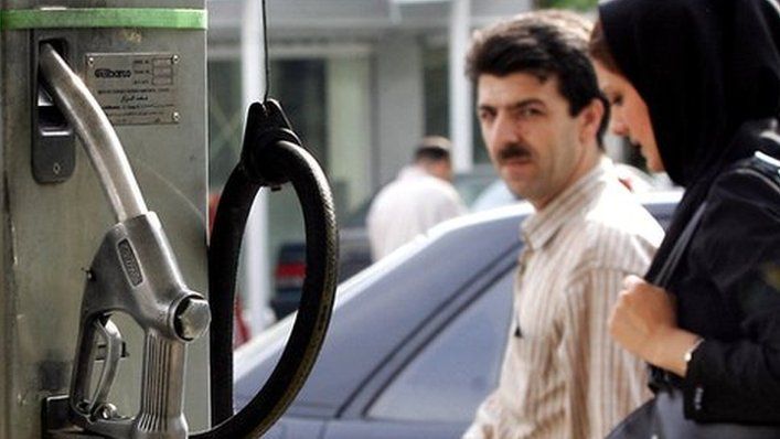 Iranian couple walks past a petrol station in Tehran (archive)