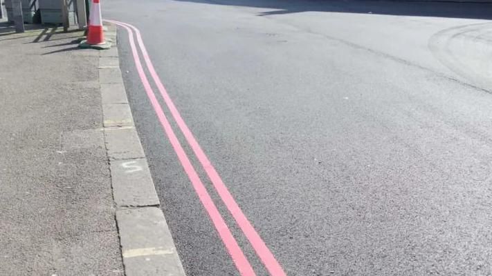 Two red lines painted on tarmac in Brighton