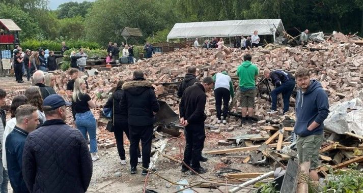 People amongst the rubble of the demolished pub