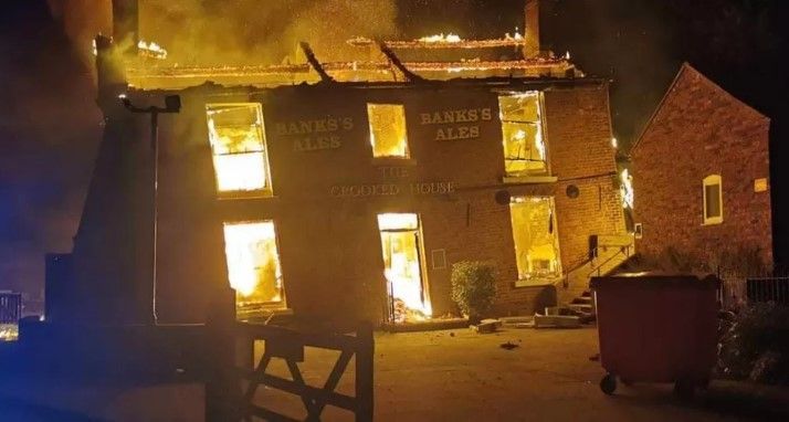 The Crooked House pub on fire