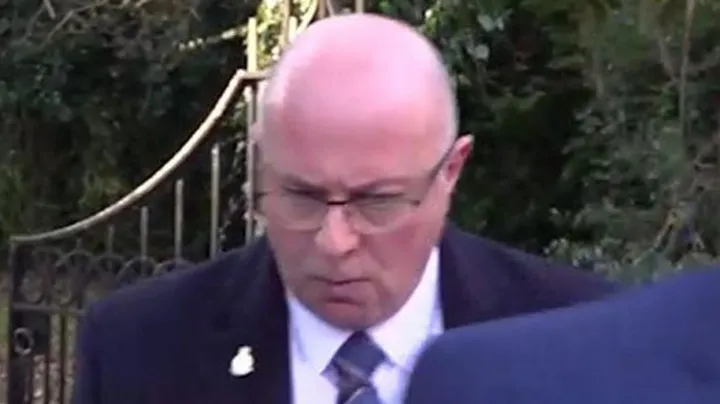 Mark Roberts in uniform beside a police vehicle