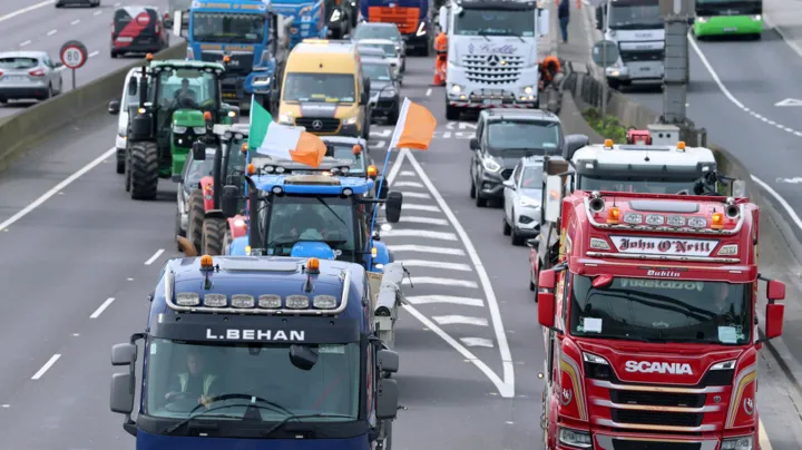 A convoy of slow‑moving vehicles blocking a Dublin street during the fuel protests