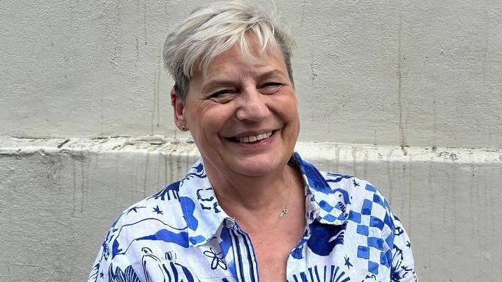 Helen Scarsbrook, smiling, in blue and white patterned shirt