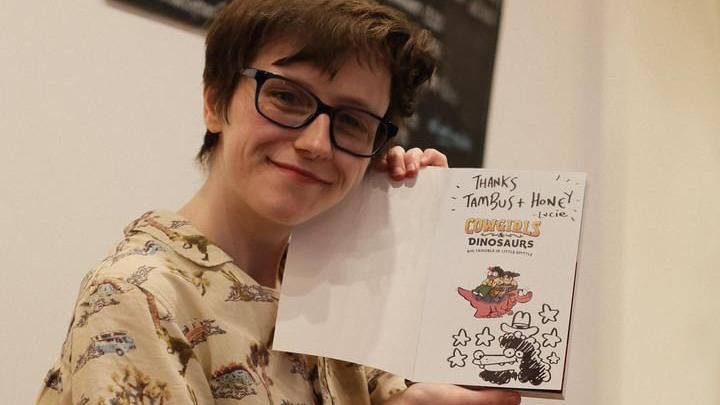 Lucie holding a copy of her new book