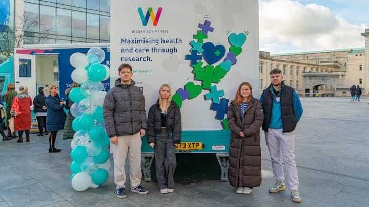 Four students with the bus they designed