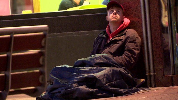 Andy West in sleeping bag on night time street