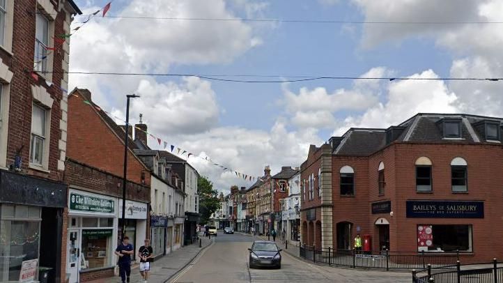 View of Fisherton Street with a car, shops and businesses on either side