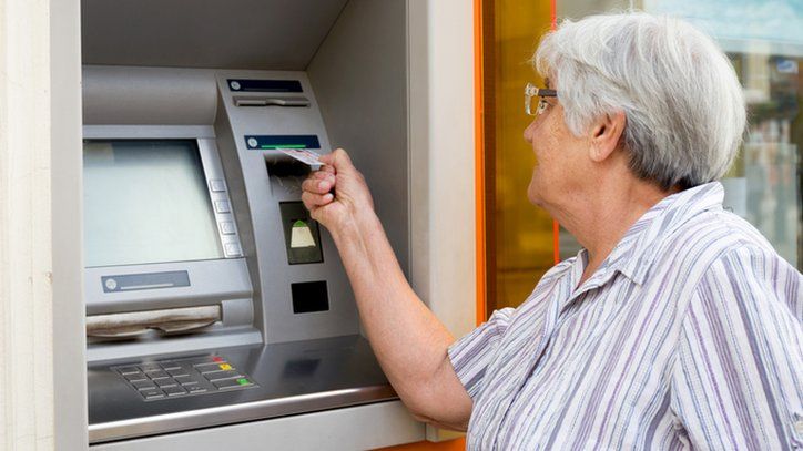 Older woman using cash machine