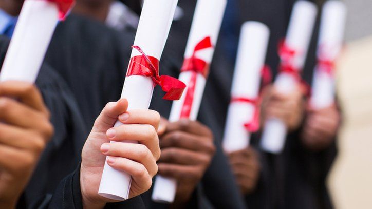 students with graduation scrolls