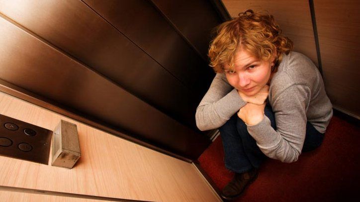 A woman feeling claustrophobic in a lift