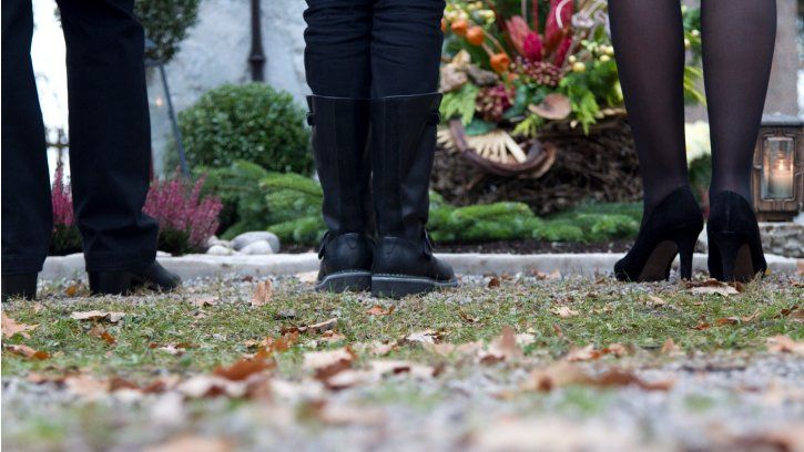 Mourners standing at grave