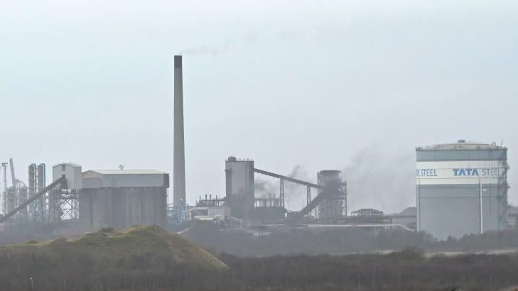 The Port Talbot steel plant seen on a hazy day, with the name Tata Steel seen on a building on the right