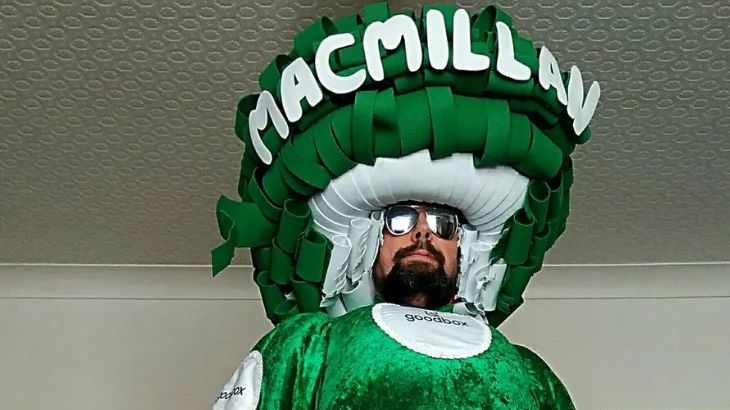 Colin wearing a huge green costume with Macmillan on the top