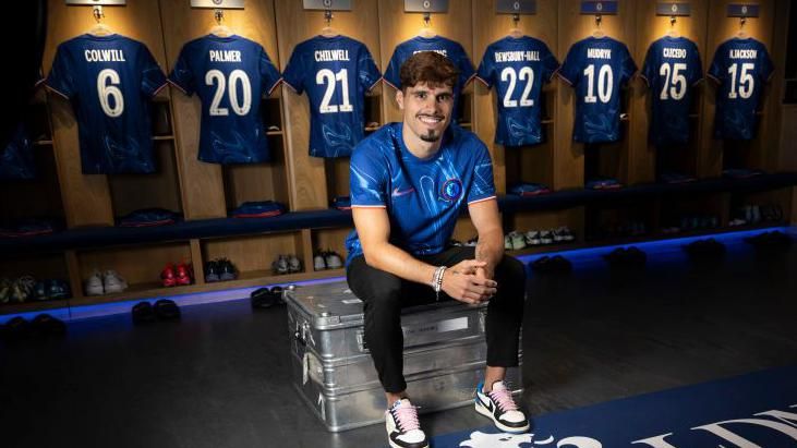 New Chelsea signing Pedro Neto sits on a bench in the club's dressing room