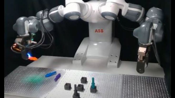 A pair of robotic hands preparing to pick up little colourful plastic objects