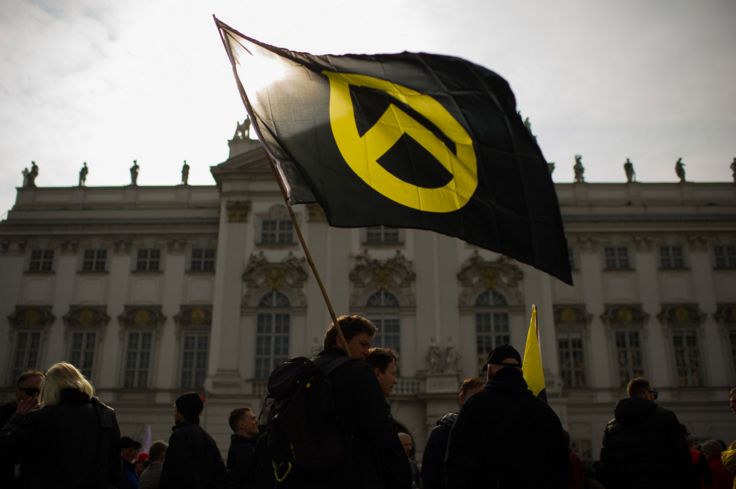 متظاهر يلوح بعلم عليه شعار "جيل الهوية" مقابل مبنى وزارة العدل في فيينا في نيسان / أبريل 2019