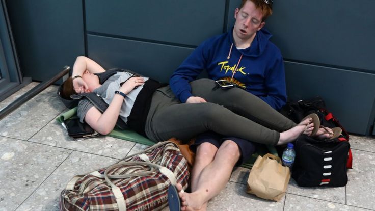 People sleep next to their luggage at Heathrow Terminal 5 in London